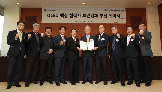 LG디스플레이는 지난 24일 파주공장에서 이방수 LG디스플레이 경영지원그룹 부사장(왼쪽에서 다섯번째)과 안경훈 산업기술보호협회 부회장(왼쪽에서 일곱번째)을 비롯한 협력사 대표, 관계자들이 참석한 가운데 'OLED 핵심 협력사 보안강화 추진' 협약식을 가졌다. <LG디스플레이 제공>